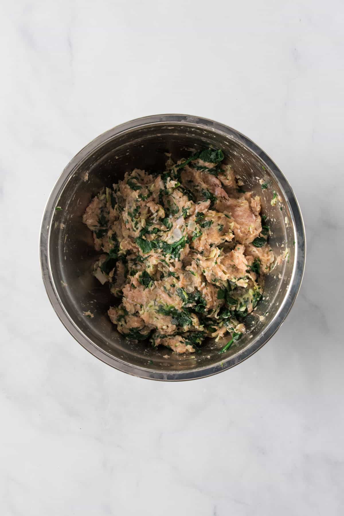 Veggie turkey meatballs meat mixture in a stainless steel bowl, mixed well.