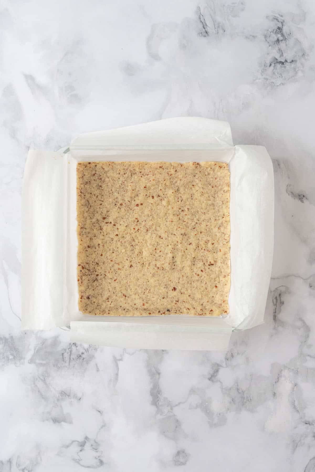 Pecan shortbread crust baked until lightly golden brown in a 9x9 baking dish.