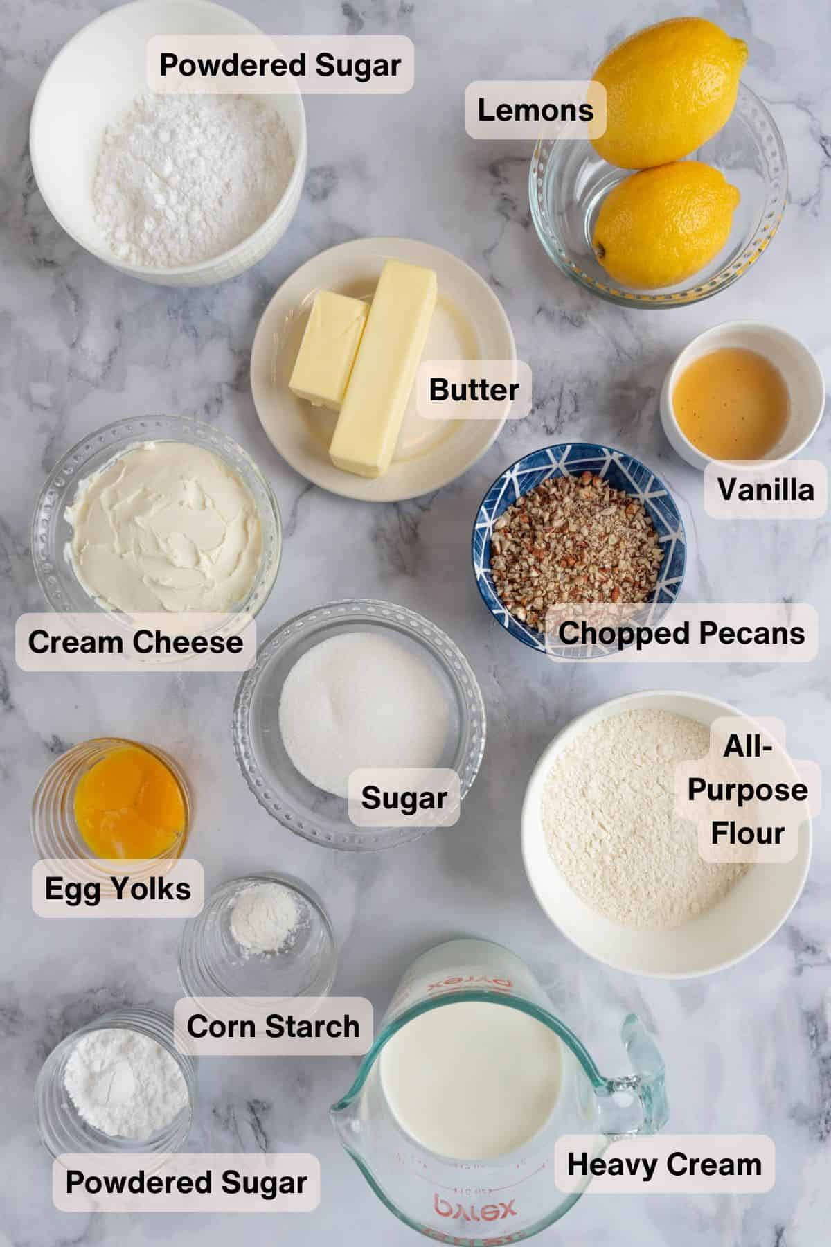 Lemon Lush Dessert from Scratch ingredients in bowls and measuring cups on a grey marble countertop.
