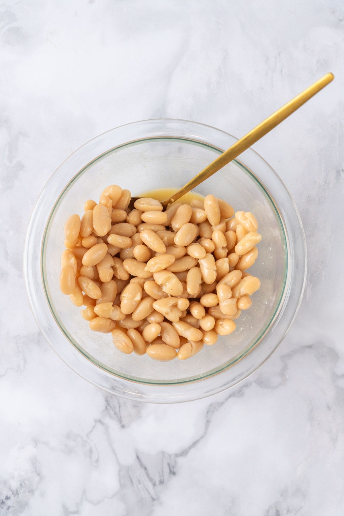 Cannellini beans marinating in dressing.