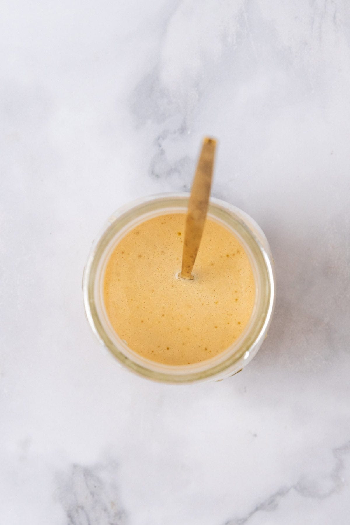 Italian vinaigrette dressing in a mason jar on a white marble background.