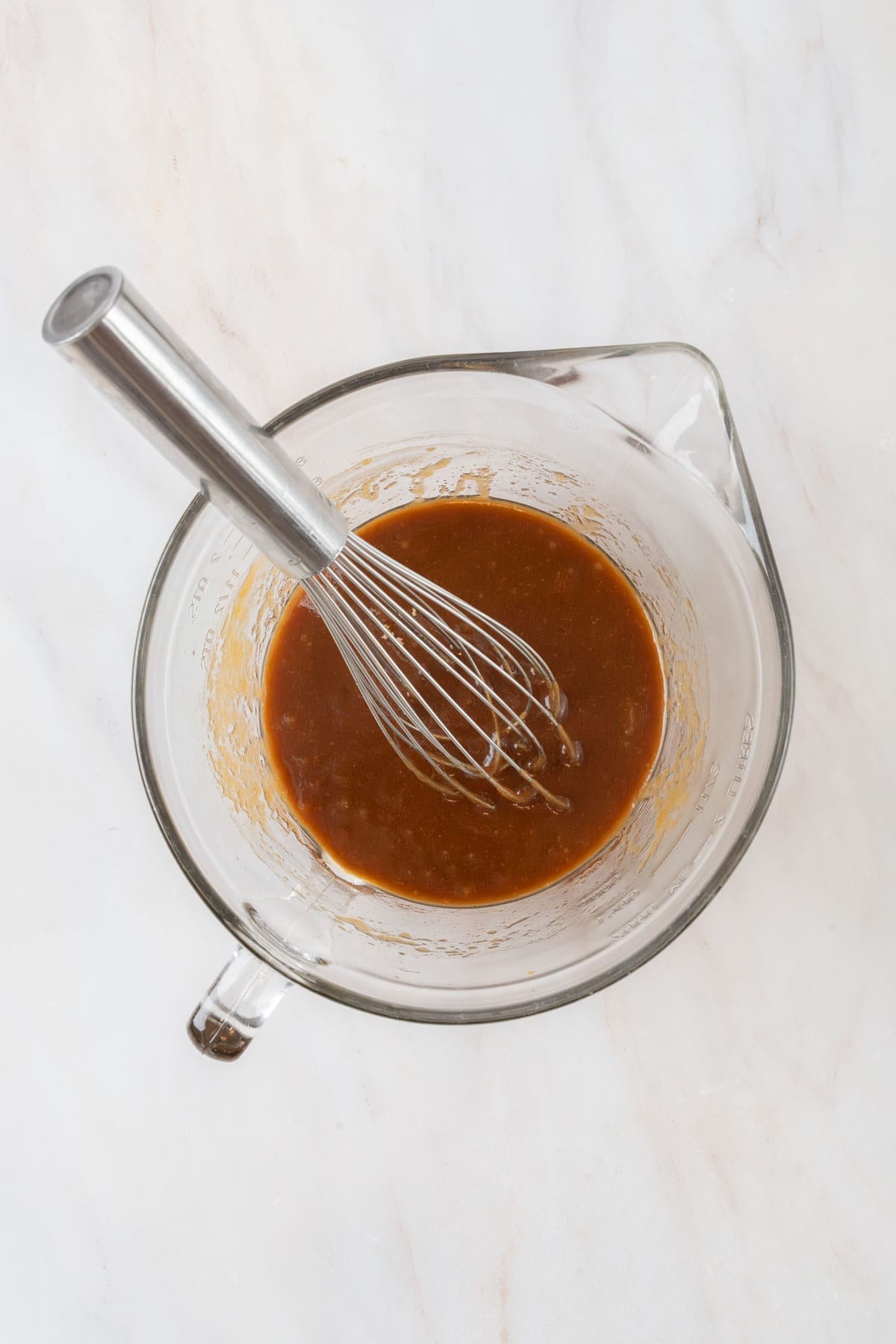 Wet blondie batter ingredients whisked together in a large glass mixing bowl.
