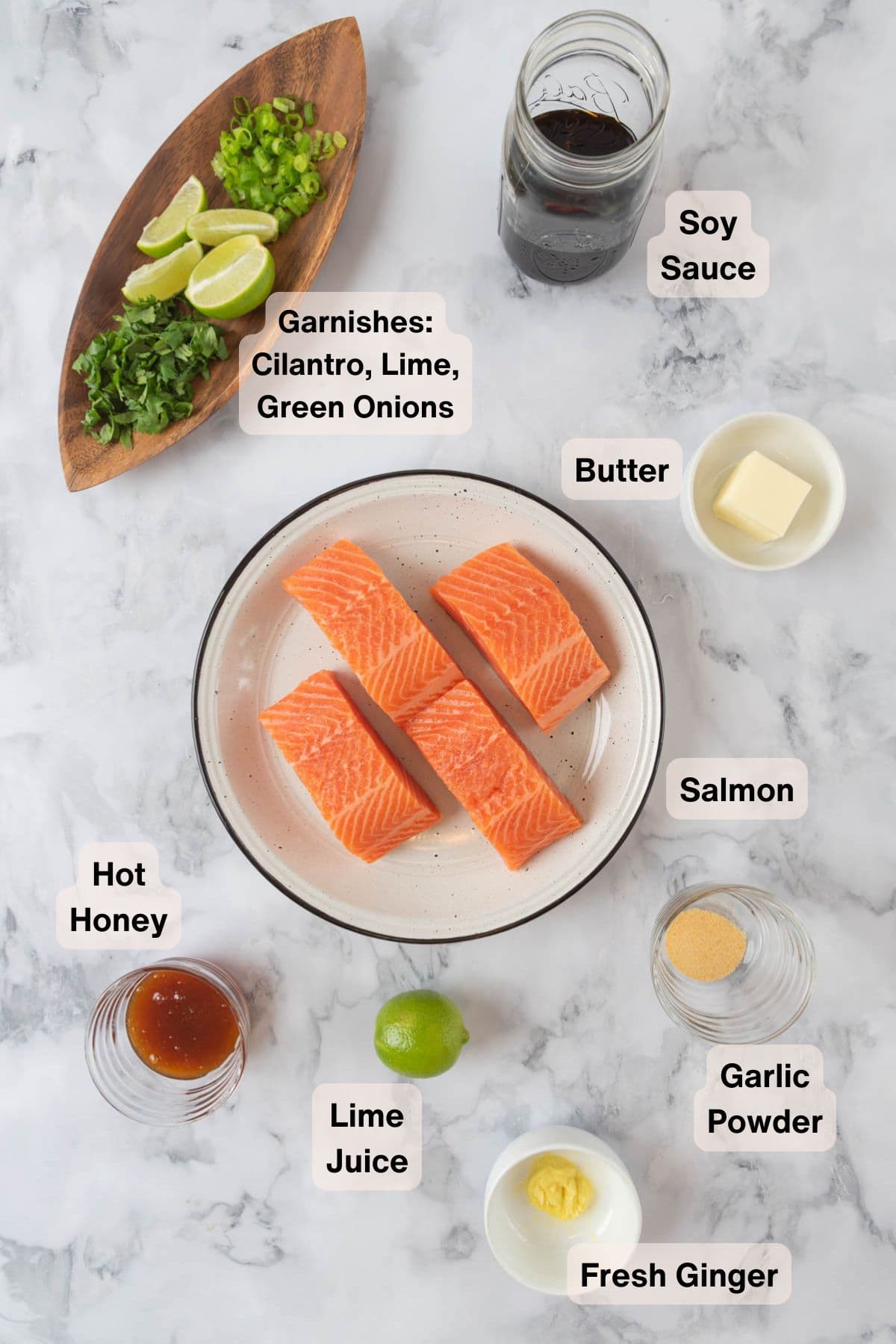 Ingredients for hot honey salmon in various plates and dishes, scattered around a countertop.