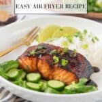 Beautifully glazed hot honey salmon plated with rice and sliced cucumber. The dish is garnished with cilantro and sliced green onions. A black and white striped linen napkin in the foreground with a bottle of hot honey and a wooden tray with more garnishes in the background. Graphics for Pinterest.