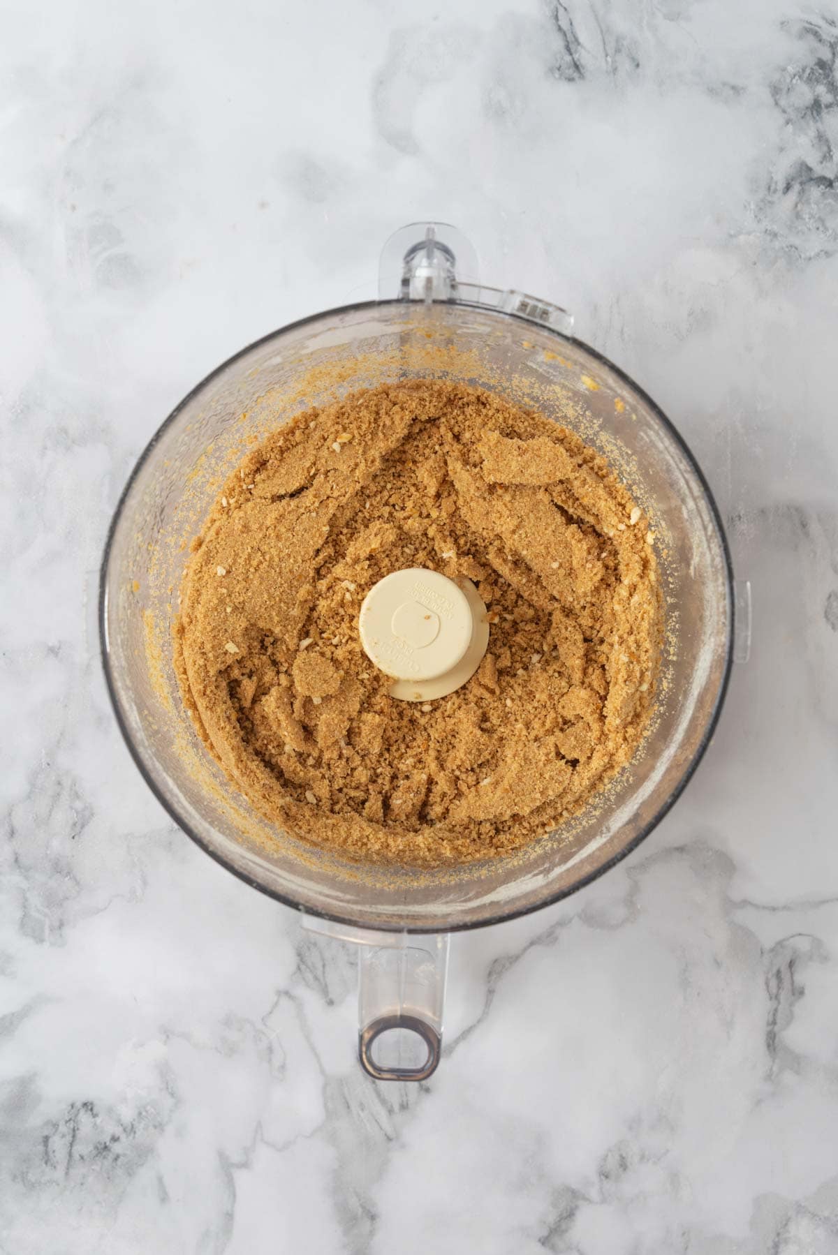 Pretzel and graham cracker crust in a food processor bowl.