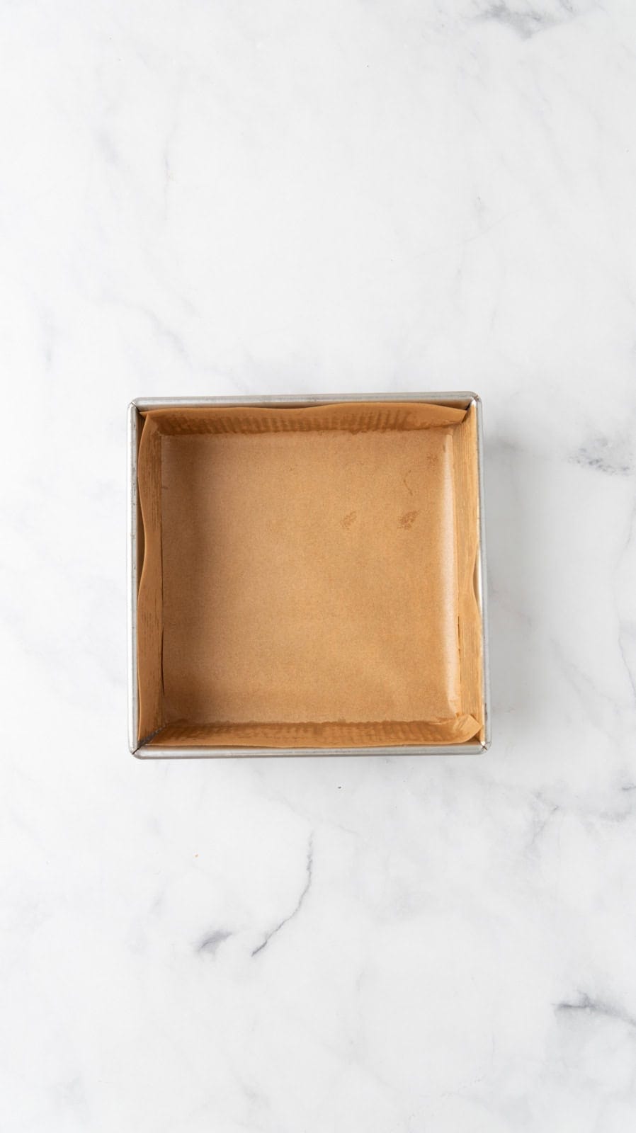 An 8x8 pan prepared with parchment paper.