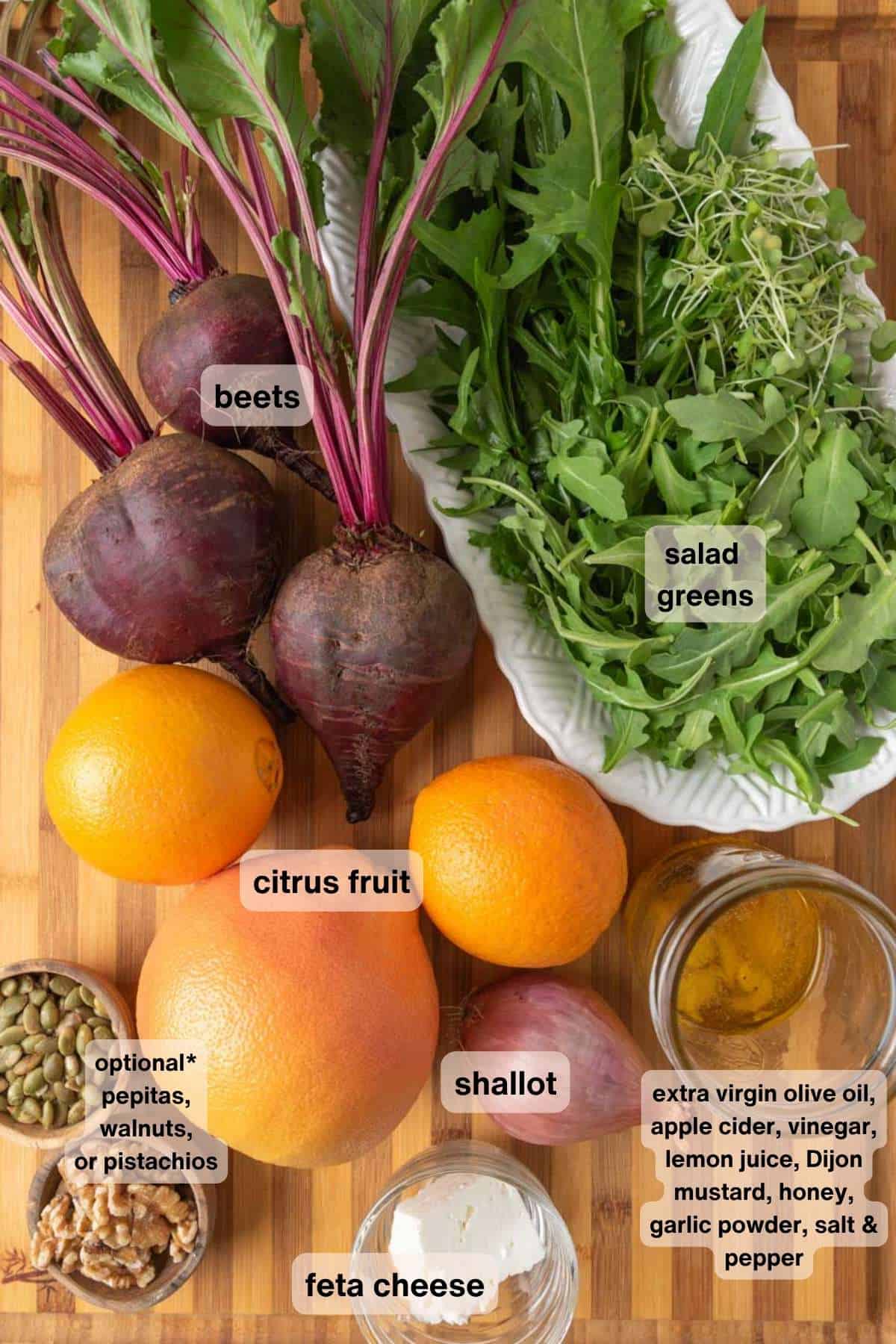 Ingredients for a beet and citrus salad with feta cheese all resting on a wooden cutting board.