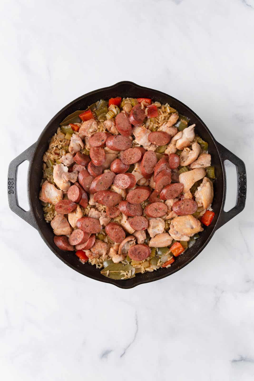 A cast iron skillet with chicken dirty rice just finished on the stove.