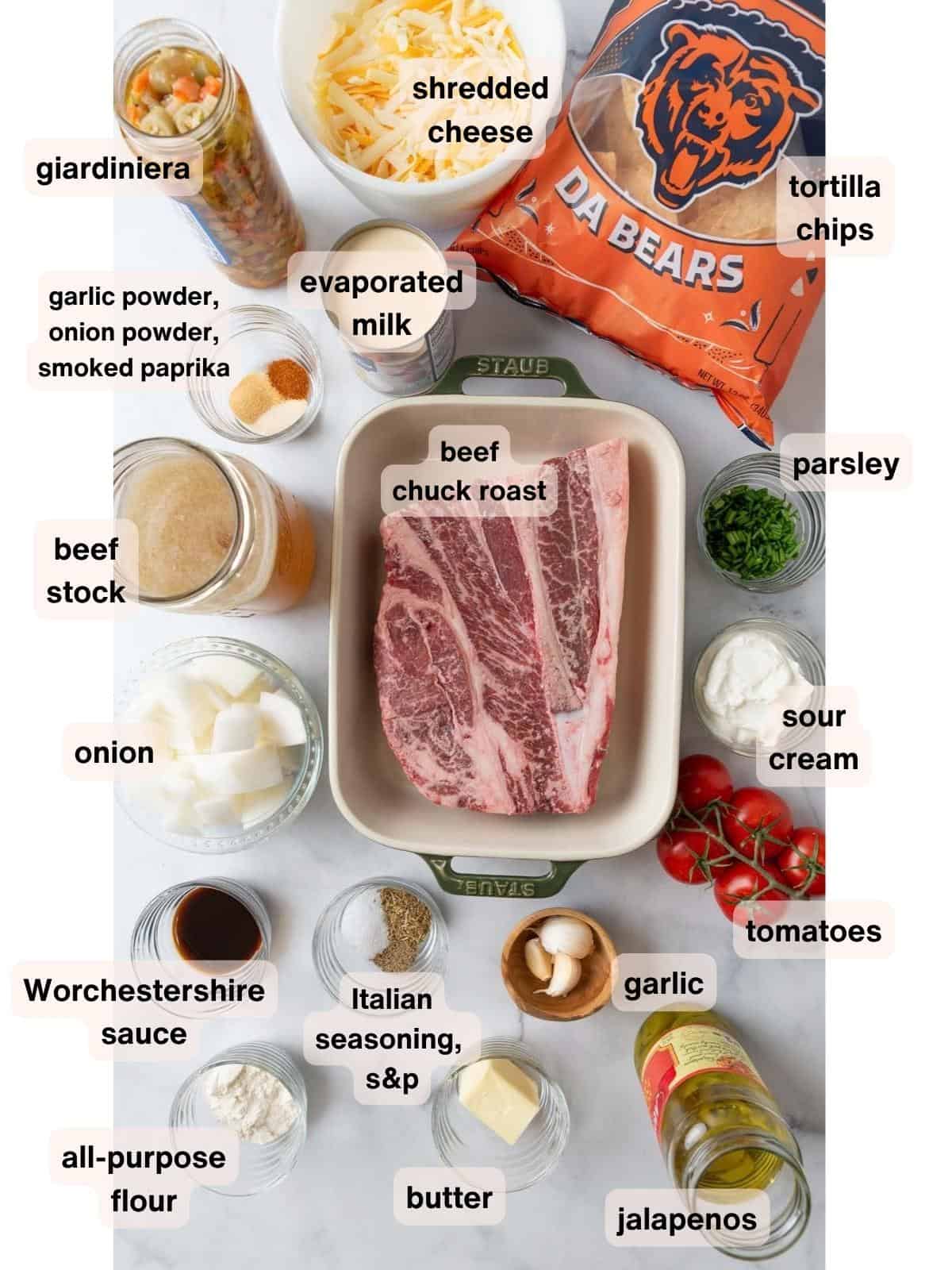 All the ingredients for pot roast nachos in various bowls and dishes resting on a white marble countertop.